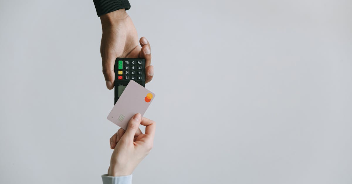 Two hands, one holding a credit card and the other holding a point-of-sale terminal, suggesting digital transactions.