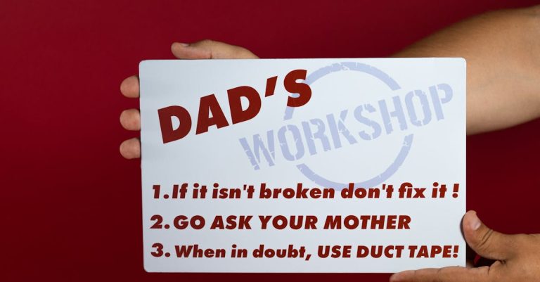 Hand holding a workshop sign with tips: 'If it isn’t broken don’t fix it!', 'Go ask your mother', and 'Use duct tape when in doubt'.