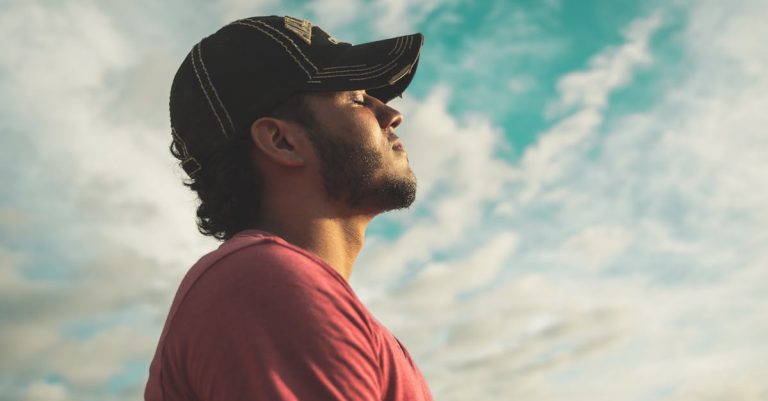 A person wearing a VR headset outdoors, with a serene sky in the background, likely using virtual reality for relaxation or stress management.